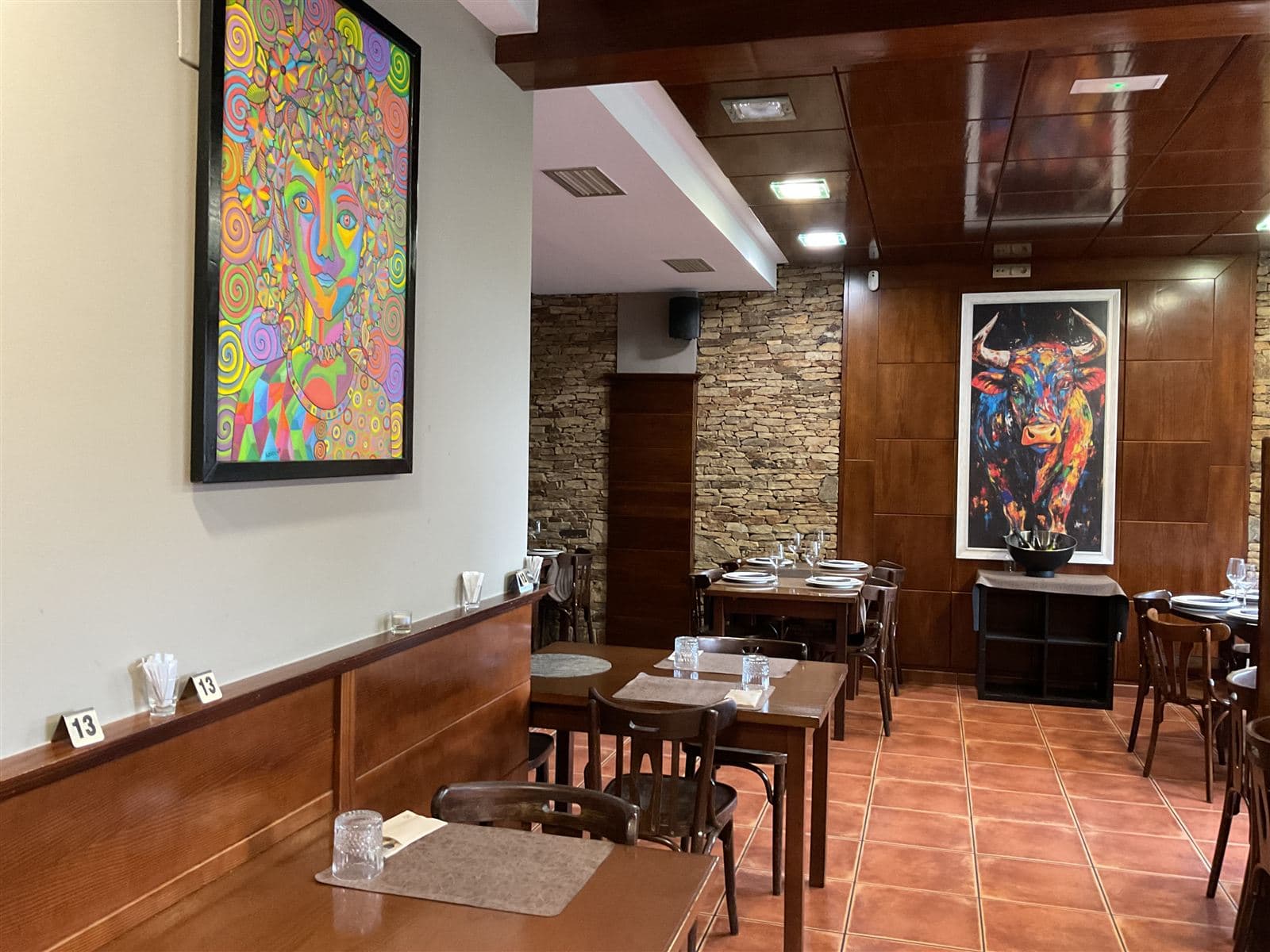 Comedor decorado con cuadros en el restaurante Asador O Carmelo de Teo