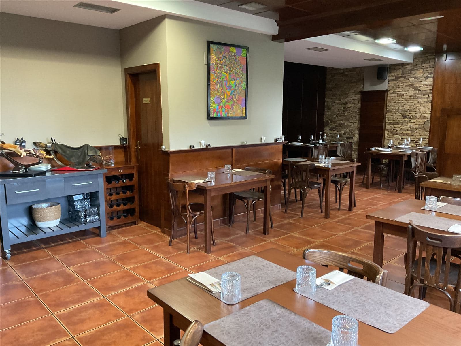 Salón con mesas preparadas en el asador O Carmelo de Teo